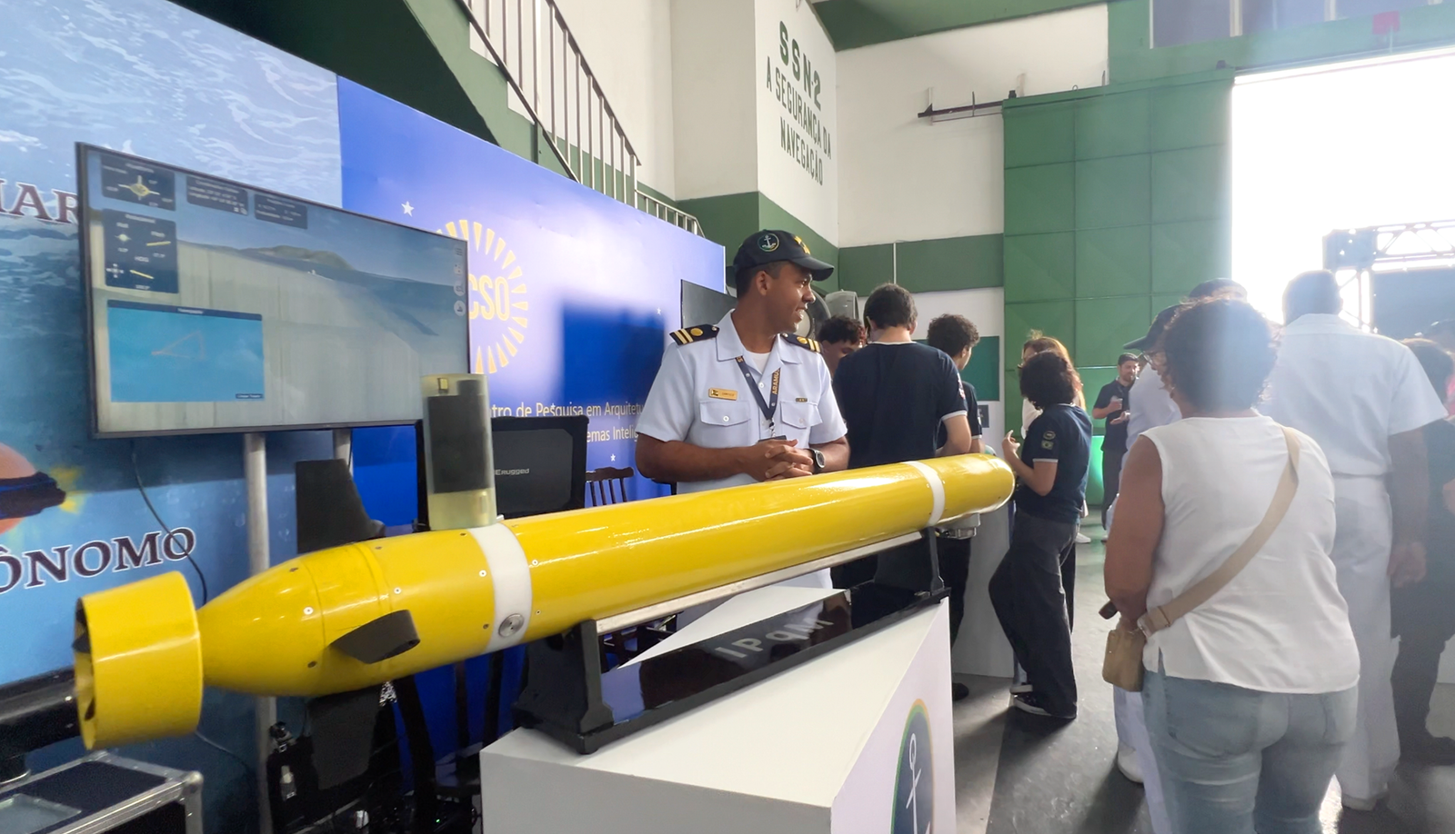 Militar da Marinha apresentando veículo autônomo subaquático (AUV) em estande da ARAMUSS